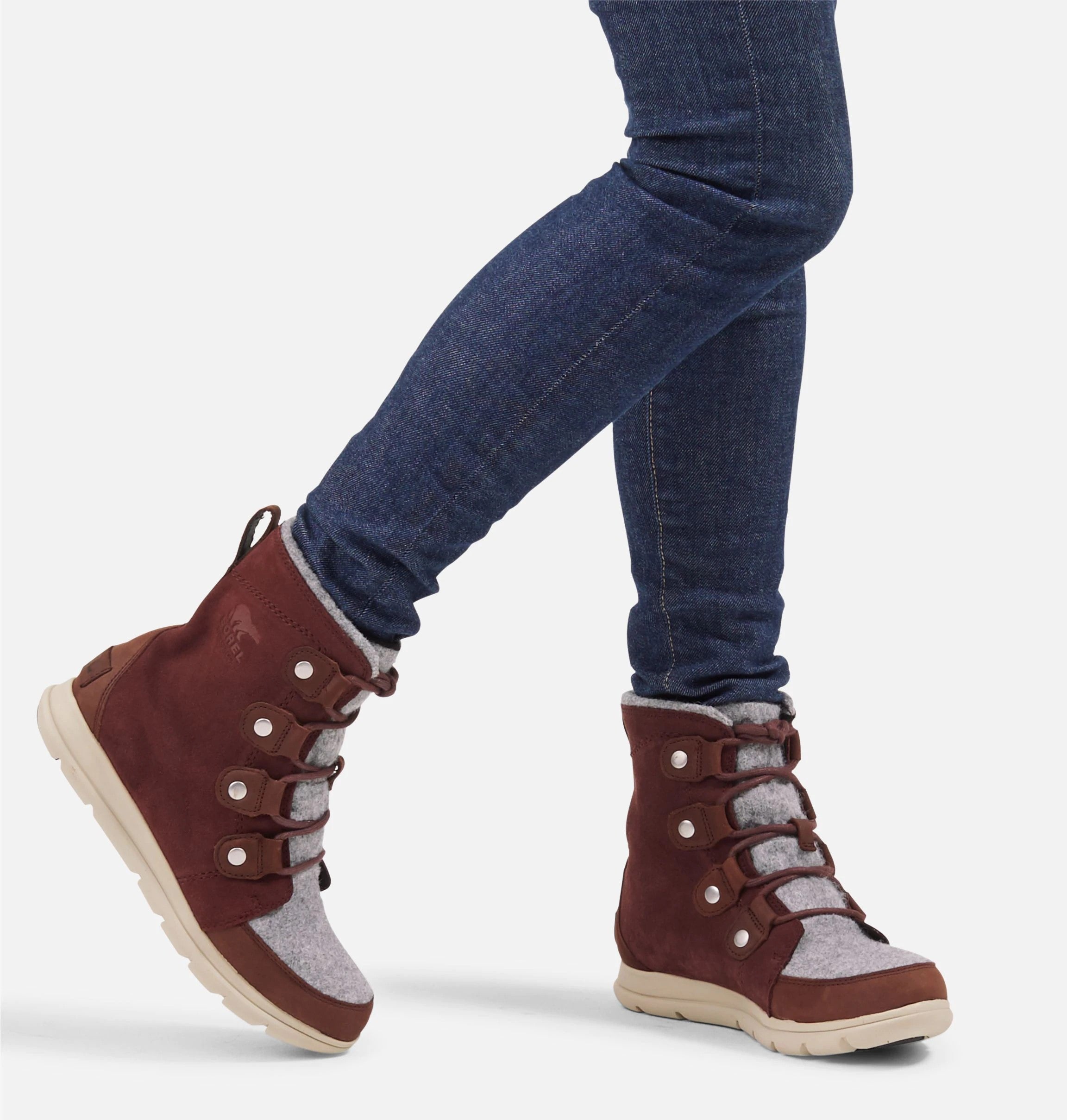 Front view of model wearing reddish brown suede ankle boot.  Picture shows how a user would look like wearing the boots. 