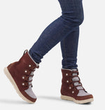 Load image into Gallery viewer, Front view of model wearing reddish brown suede ankle boot.  Picture shows how a user would look like wearing the boots. 
