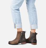 Load image into Gallery viewer, Rear view of female model wearing brown 2 tone winter boot. Made of leather and suede and has a zipper. Heel made of wood is also visible.
