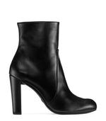 Load image into Gallery viewer, Side view of glossy black leather boot on white background.
