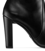 Load image into Gallery viewer, Close up view of heel of glossy black leather boot.
