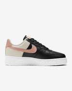 Load image into Gallery viewer, Side view of Nike running shoe. Has white midsole, pink Nike logo and colour is two tone black and beige leather.
