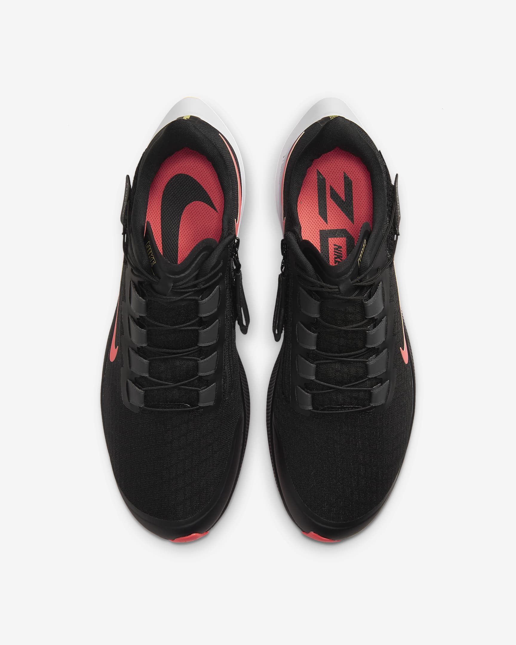 Top view of a pair of black Nike running shoes. Have black laces and red Nike logo.