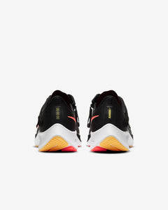 Rear view of black running shoes on white background. Has white midsole and running is written on the back of the shoe.