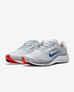 Load image into Gallery viewer, Front right view of a pair of Grey Nike shoes. Has white midsole with Air Zoom inscription and a blue Nike logo.
