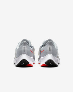 Rear view of grey Nike running shoes. Has white midsole and two tone red and black sole. 