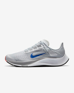 Side view of grey Nike running shoe. Has white midsole with inscription Air Zoom on the sides. Also has white laces and blue Nike logo.